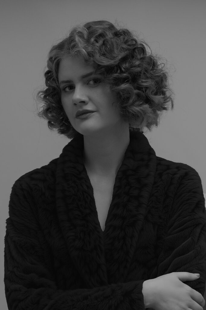 Schwarzweißfotografie eines weiblichen Körpers im Schatten, reduziert ausgeleuchtet